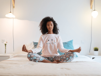 student in yoga pose on bed