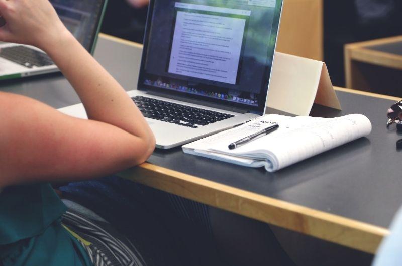 laptop, notepaper, part of person's arm