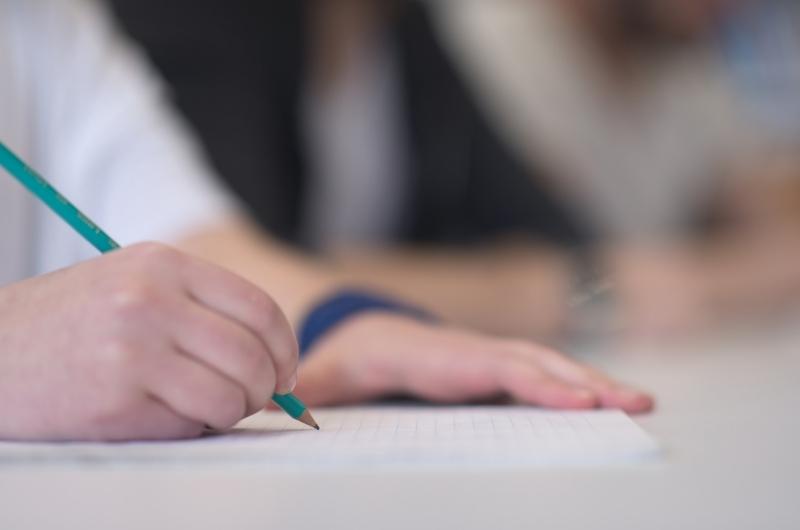 person holding pencil and writing