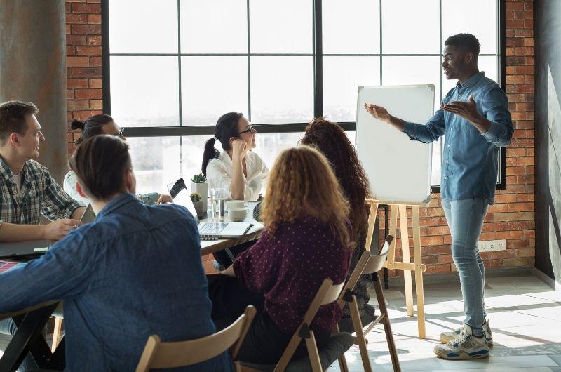 group at conference table, man standing up talking