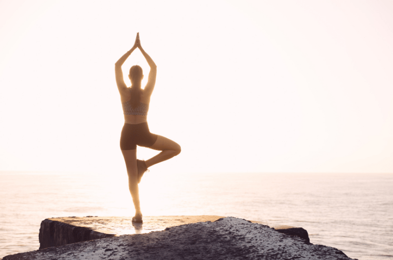 woman in yoga pose on beach