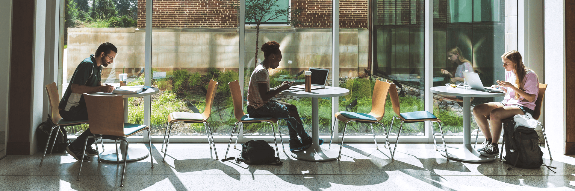 Students sittings at tables with their laptops